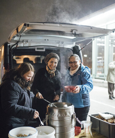 Freiwillige betreuen die Essensausgabe des Canisibus 